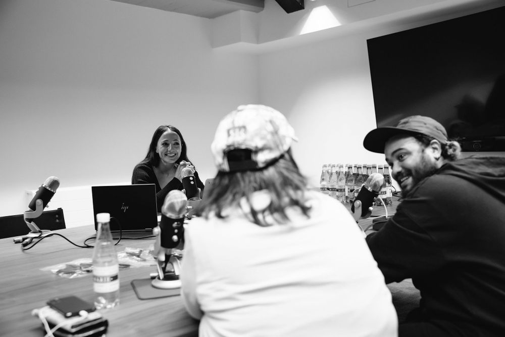 Group meeting around table with recording equipment in black and white.