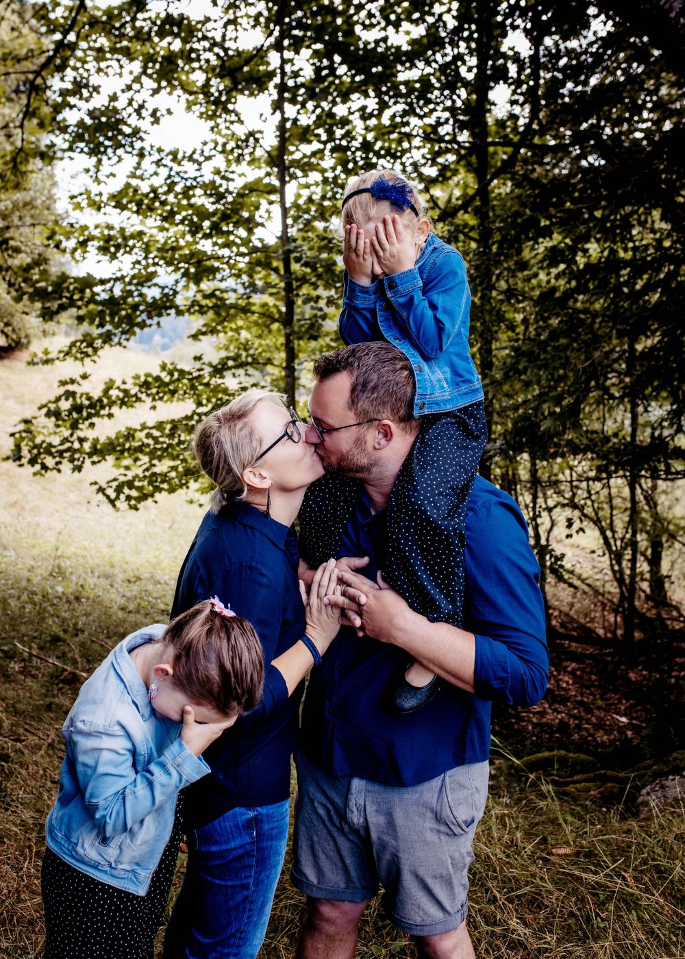Candid family moment outdoors with playful reactions and expressions in nature.
