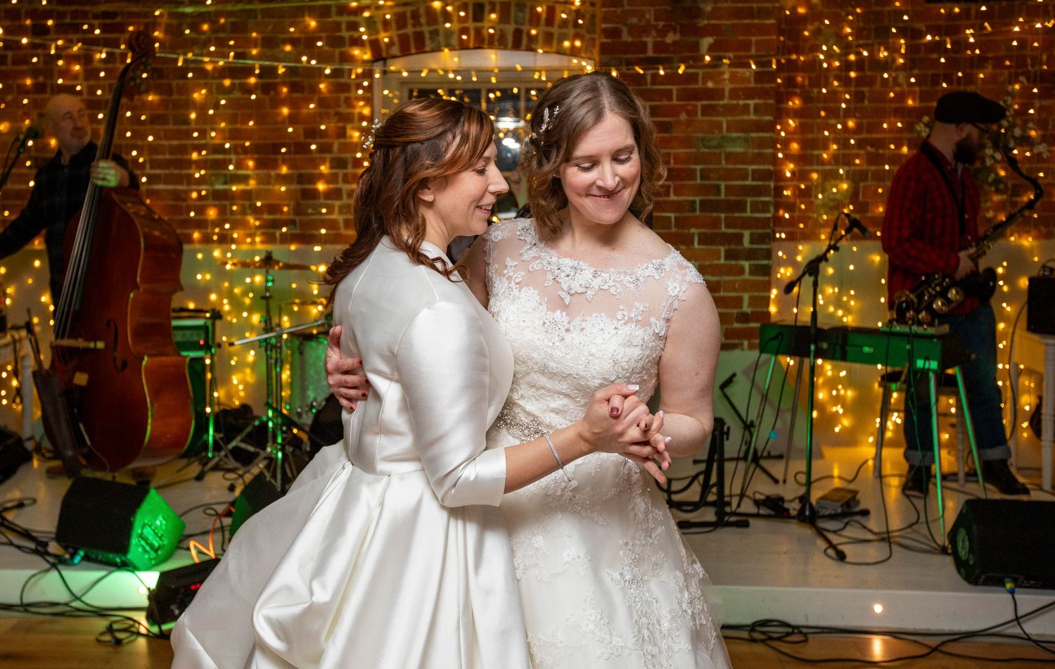 Wedding reception venue decorated with string lights and exposed brick walls.