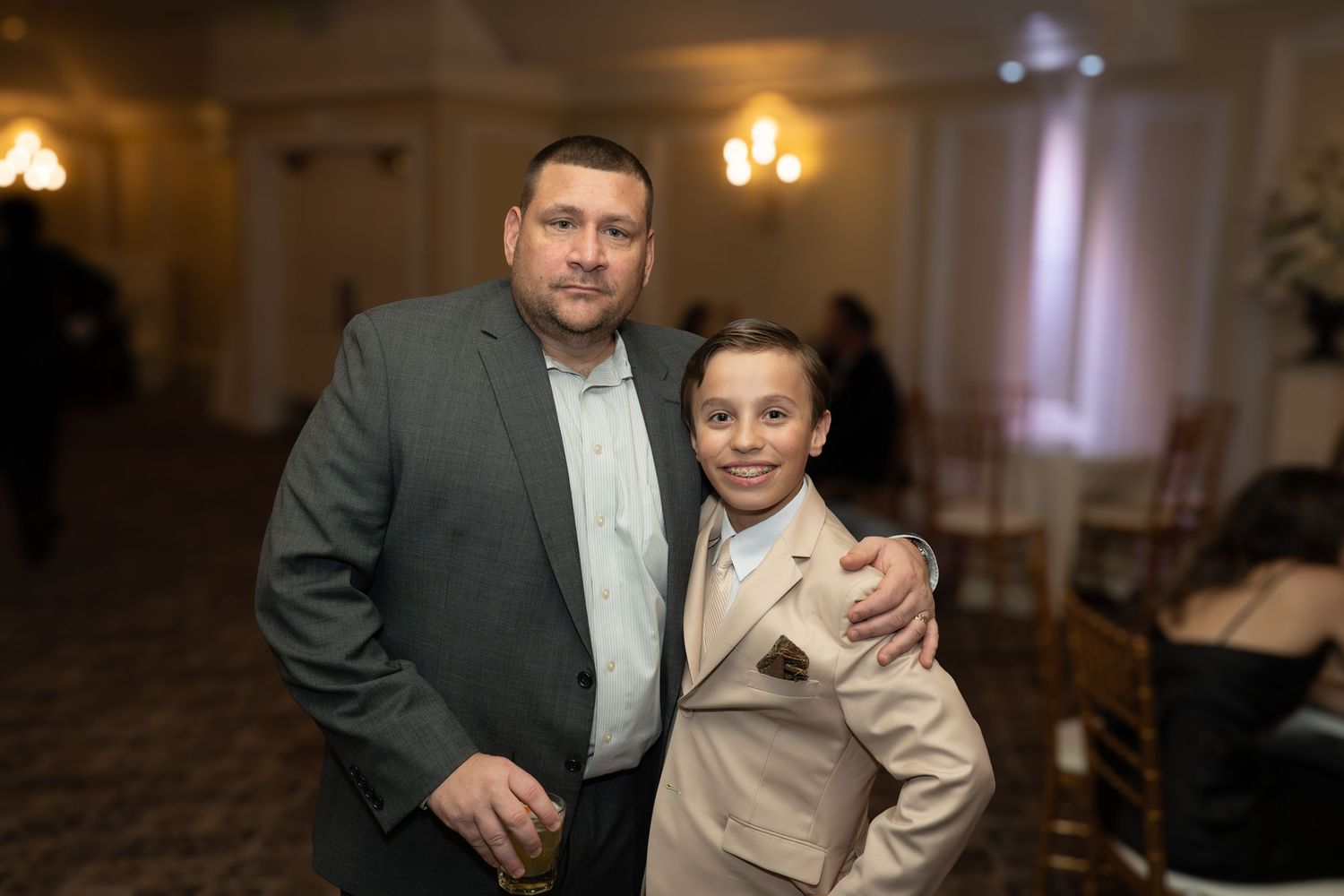 Formal event in an elegantly lit banquet hall with warm lighting.
