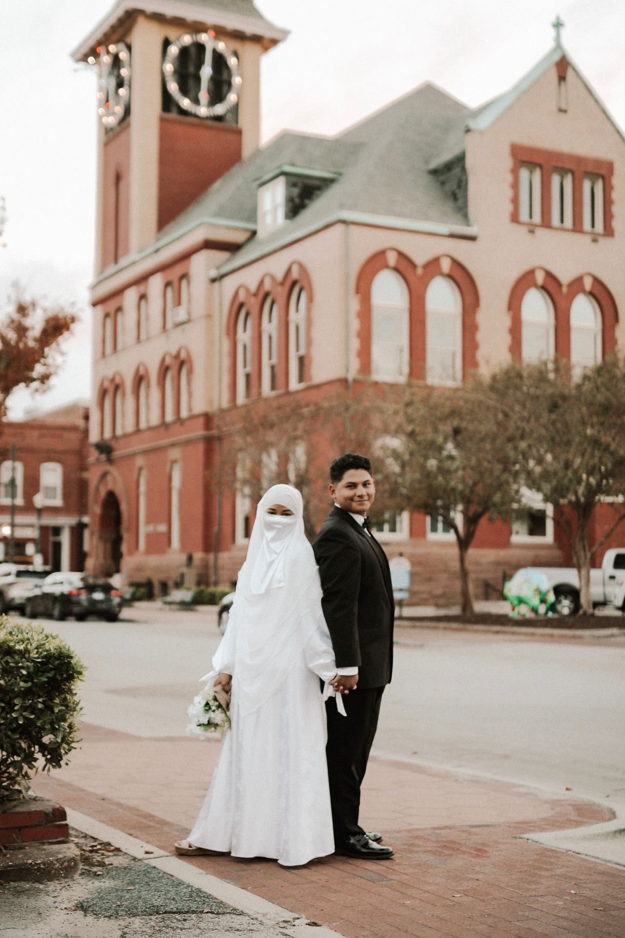 Series of wedding photos taken outside a historic brick church with red accents.