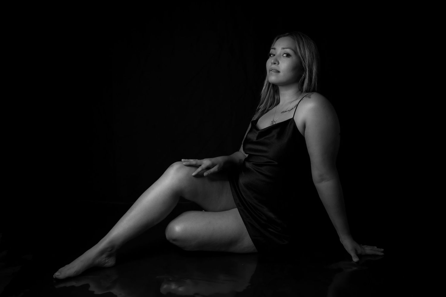 Artistic black and white portrait of a woman in silk dress.