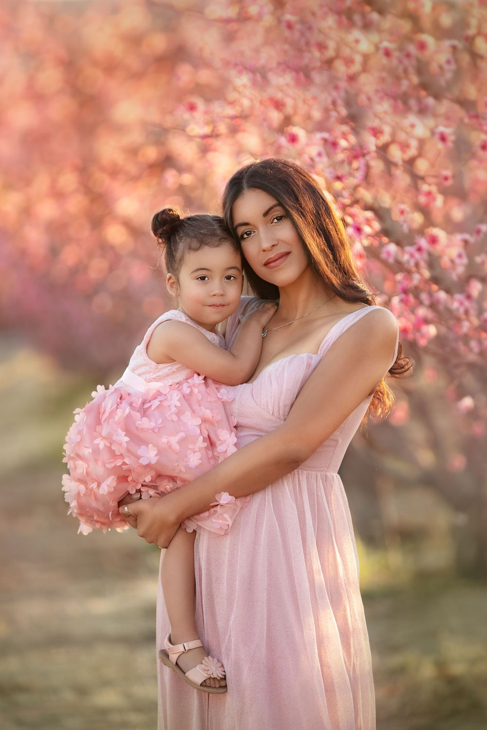 Mom embracing her daughter among the cherry blossoms in Las Vegas captured by Merrick Imagery