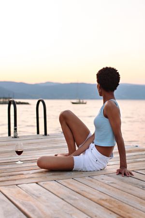 girl sitting with wine on dock