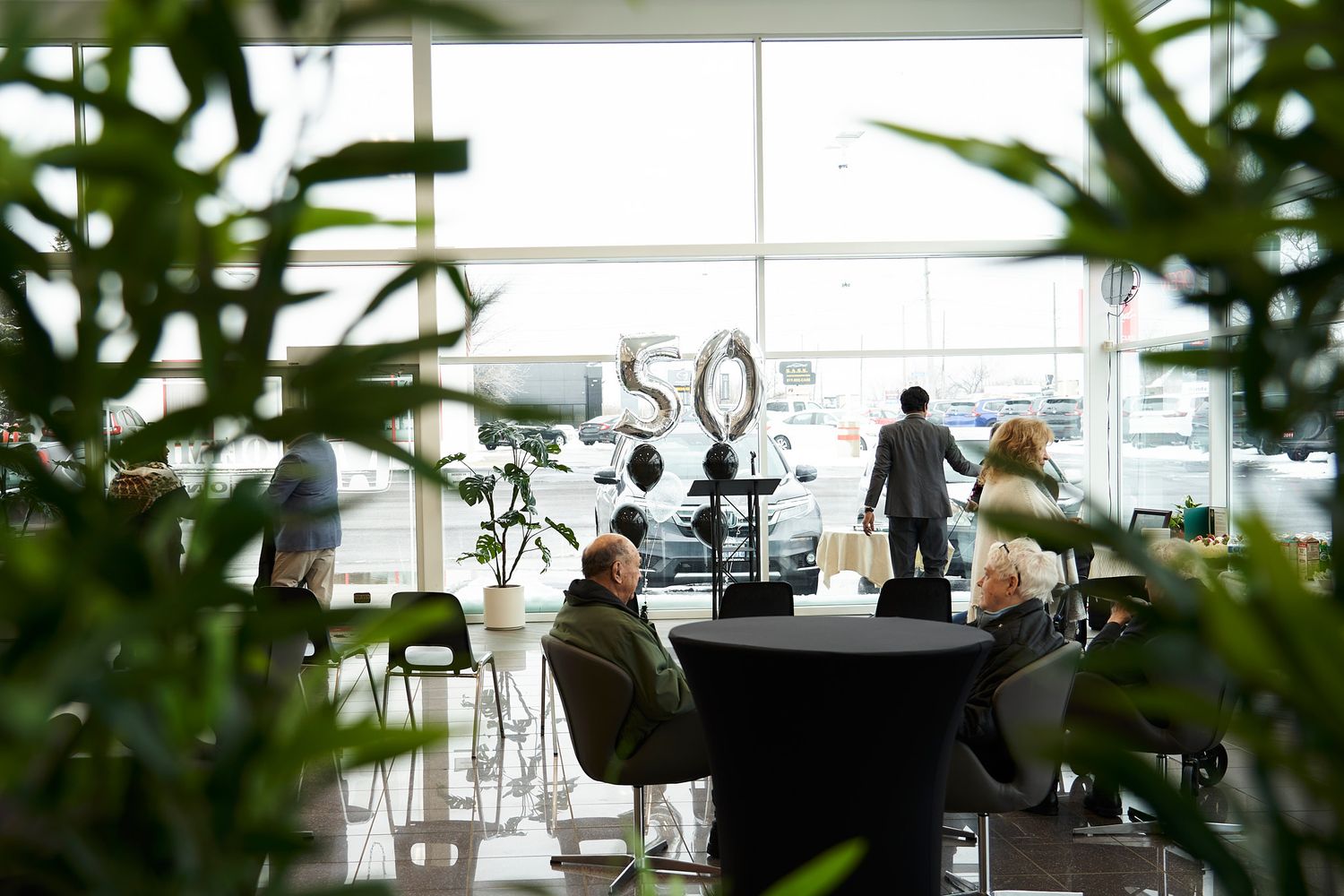 Modern event space with number 50 display seen through tropical plants.