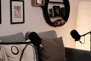 Home recording space with mounted circular shelves, microphones, and a comfortable gray sofa.