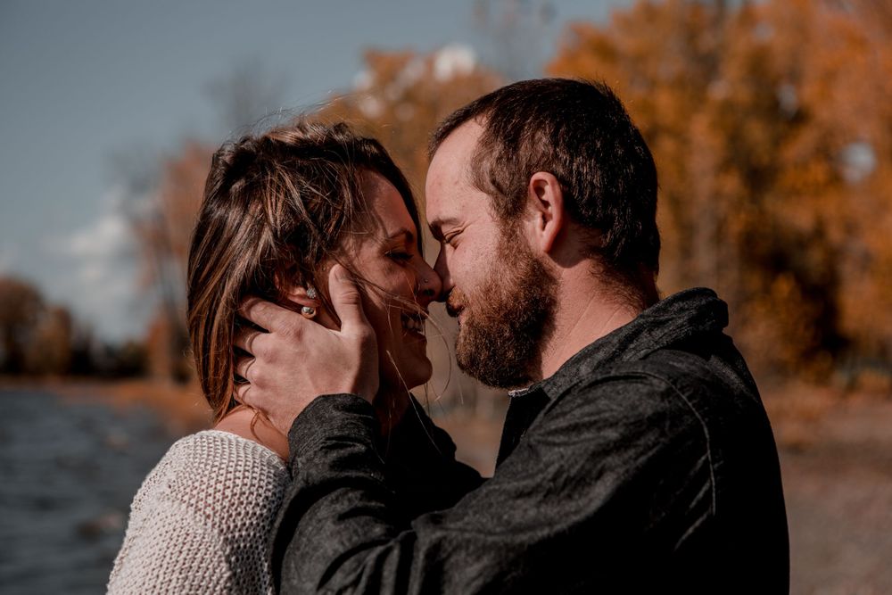 Intimate close-up of couple sharing tender moment outdoors.