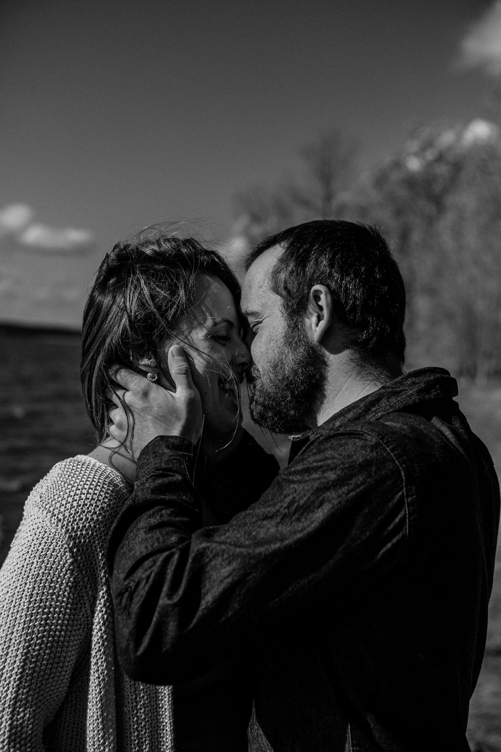 A romantic black and white photo sequence showing a couple in an intimate embrace against a moody background.