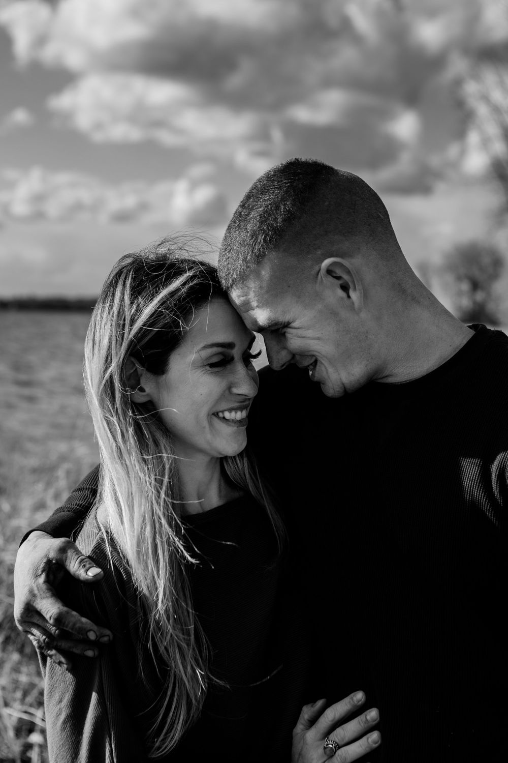 Black and white portraits capturing intimate moments between a couple sharing laughs and tender looks.