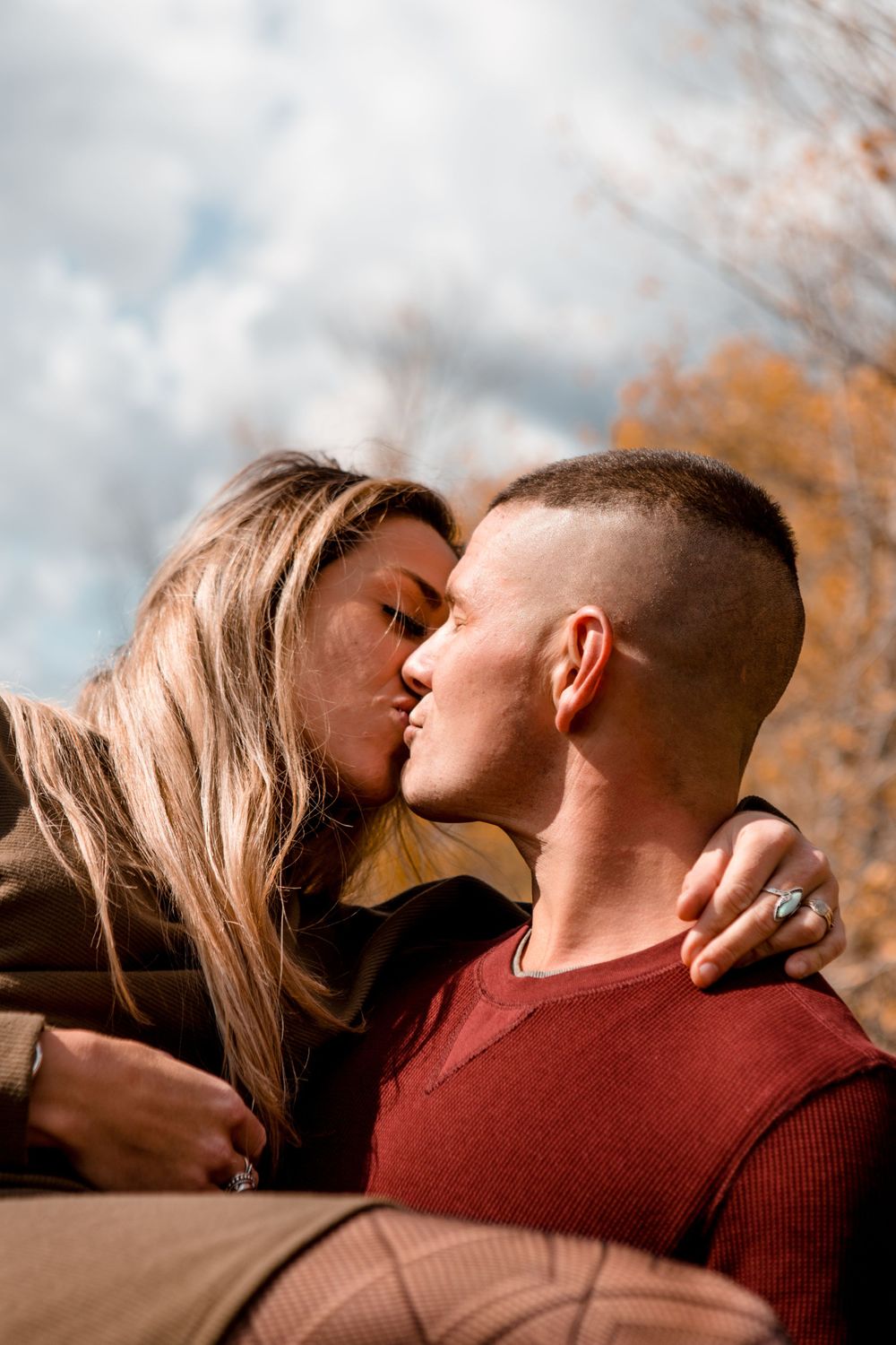 Romantic couple portraits taken during autumn featuring soft natural lighting and warm earth tones.