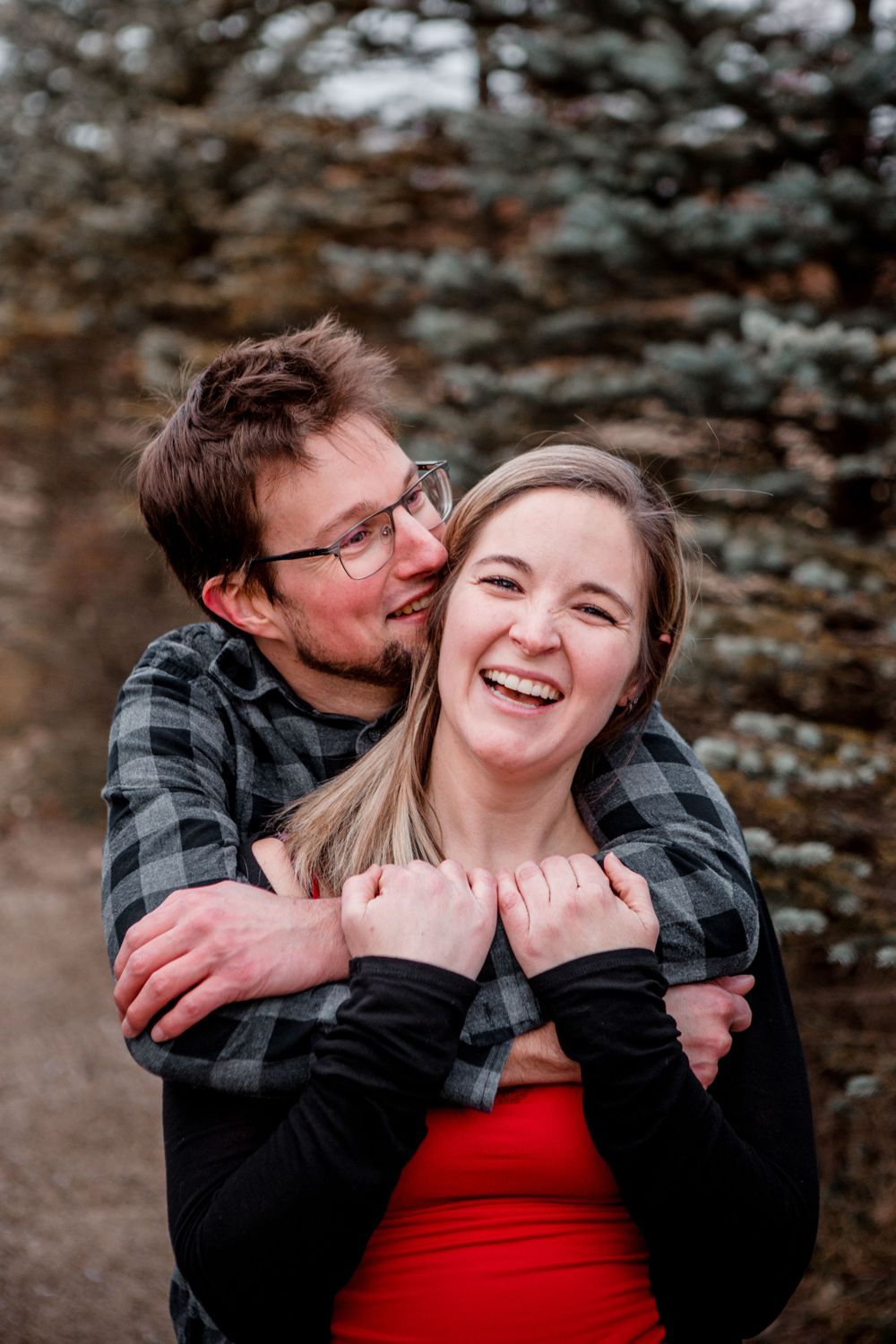 Candid engagement photos showing joyful laughter and affection between a couple in casual attire.