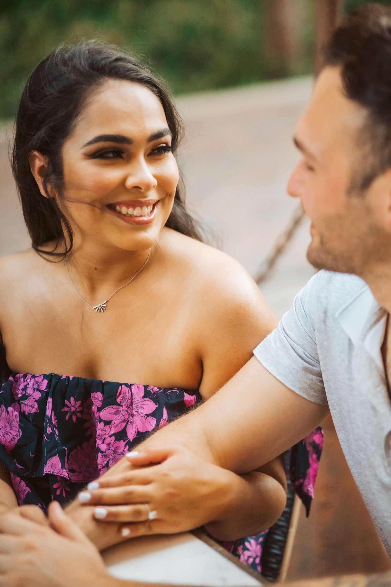 A couple shares an intimate moment during their engagement photoshoot outdoors.