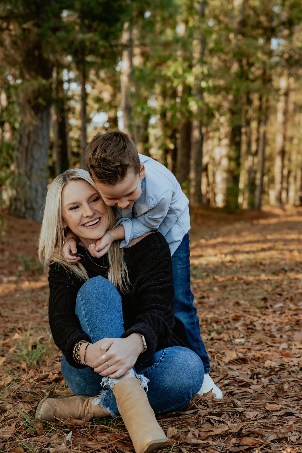 A couple shares intimate moments while sitting on fallen autumn leaves.