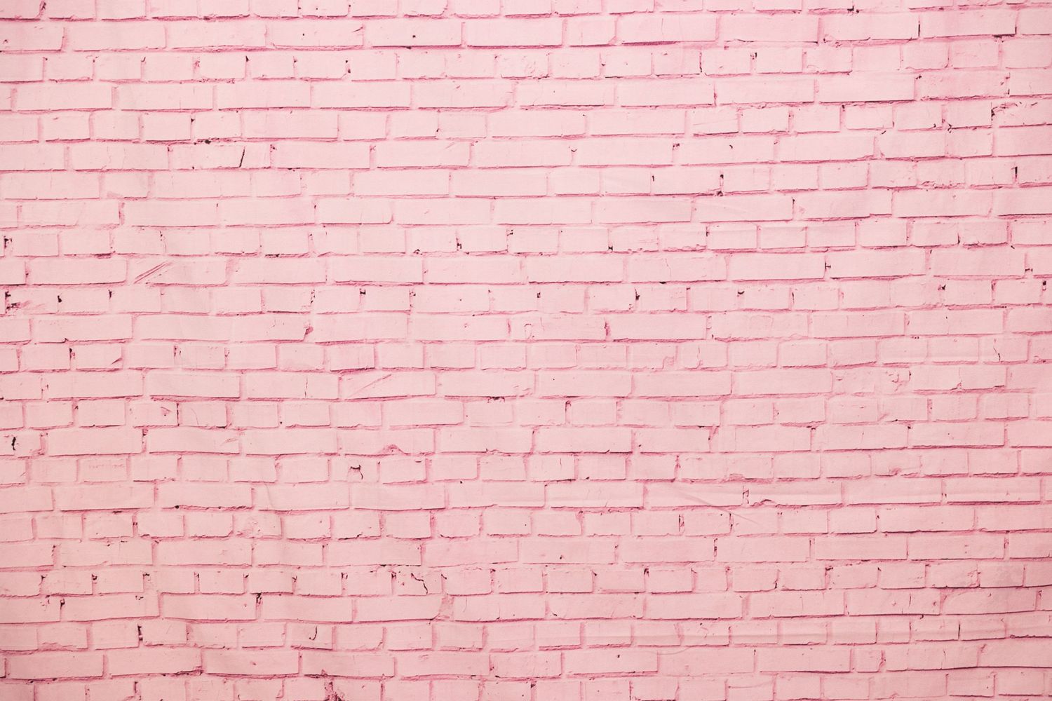 Pink painted brick wall texture with subtle shading variations.