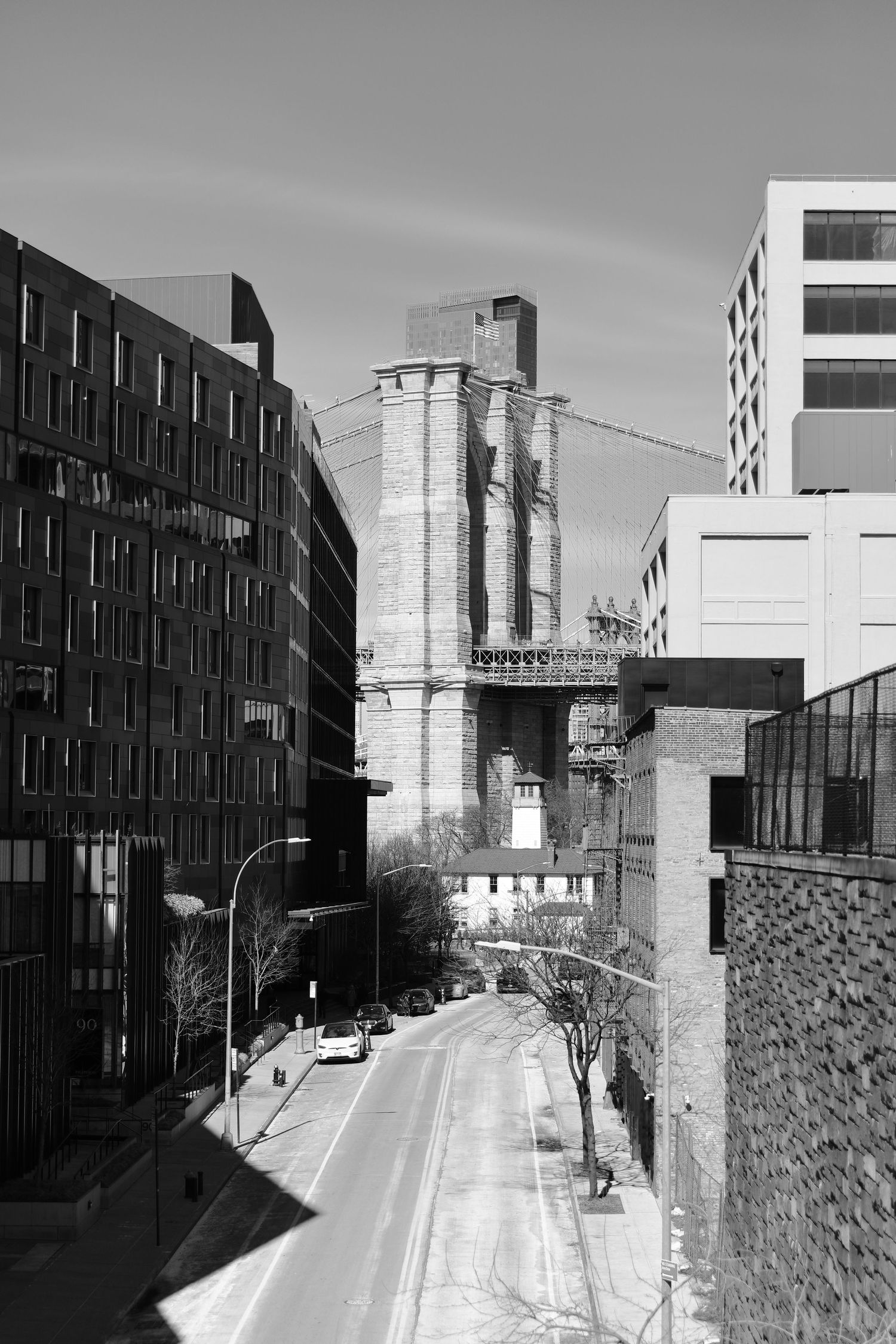 Industrial urban street view with old grain silos and modern buildings in black and white.