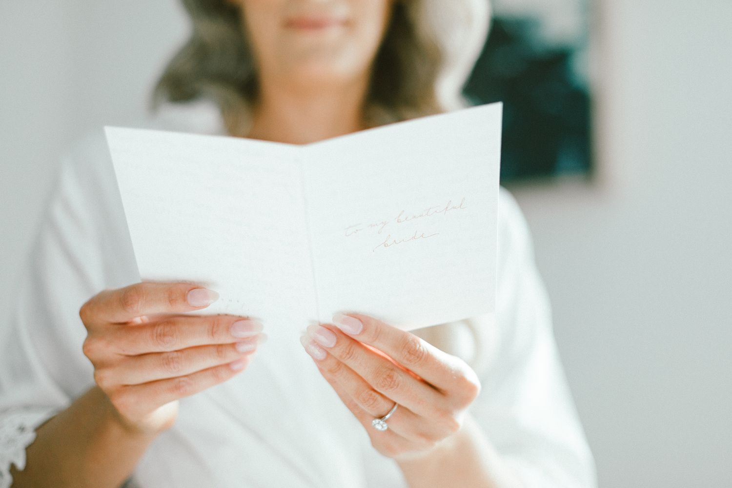 Hands holding white paper against blurred background.
