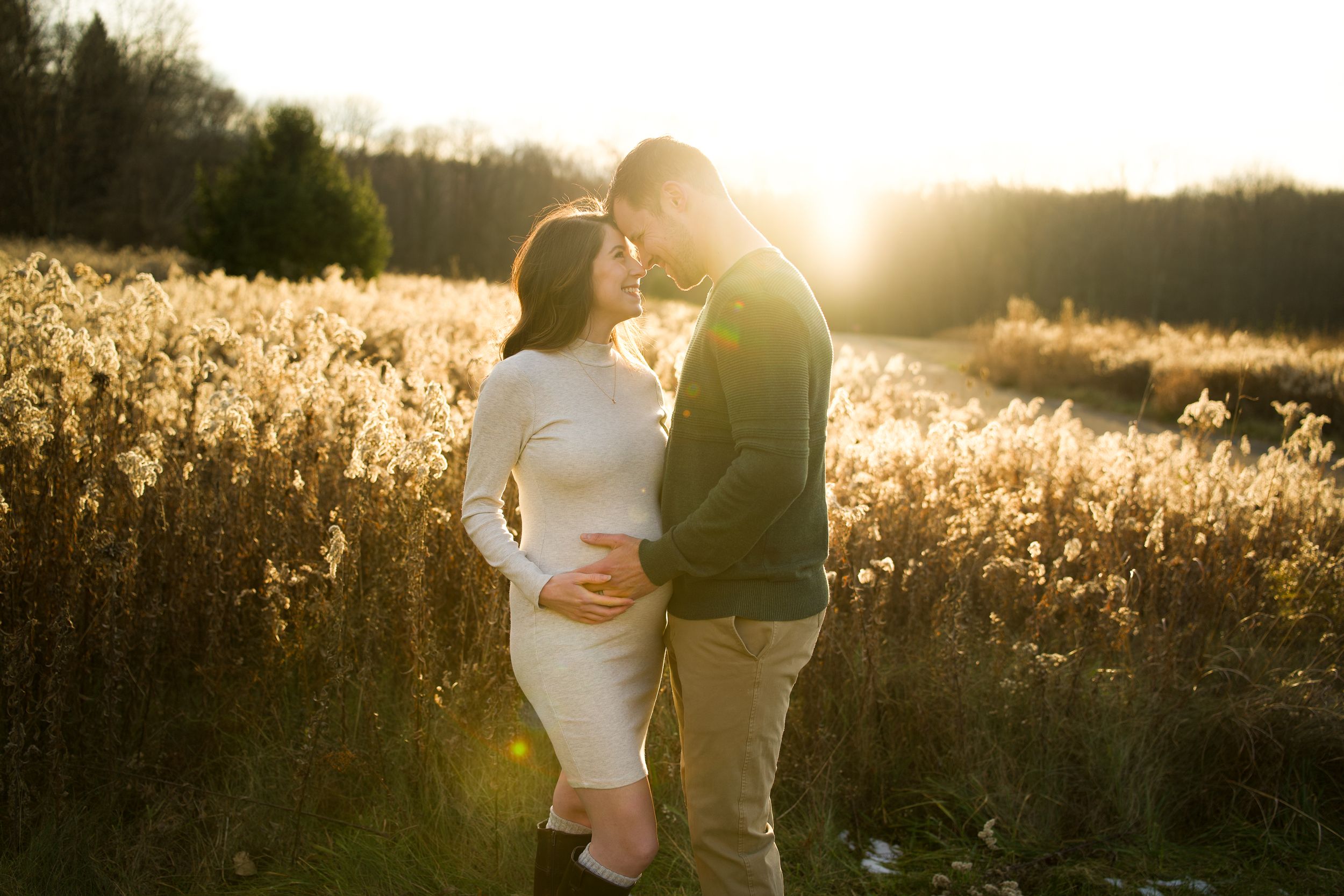 A romantic sunset embrace in a golden field of tall grass.