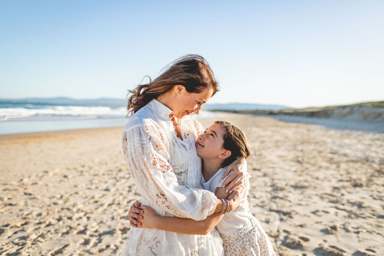 Tender moment captured between two people on a sunny beach.