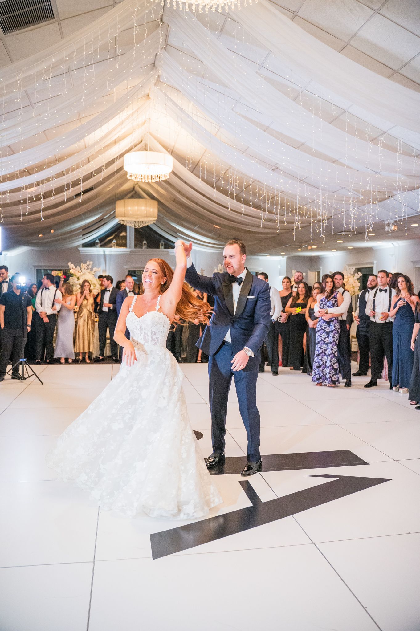 Groom twirls bride during their first dance at Flowerfield Celebrations.