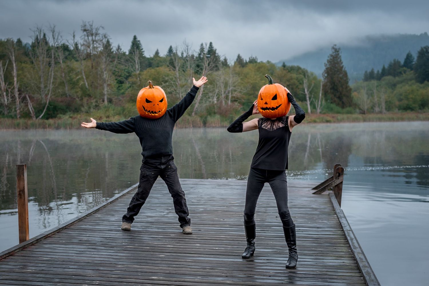 pumpkin people with jack-o-lantern heads pose on a lake dock on Salt Spring Island, BC for photos