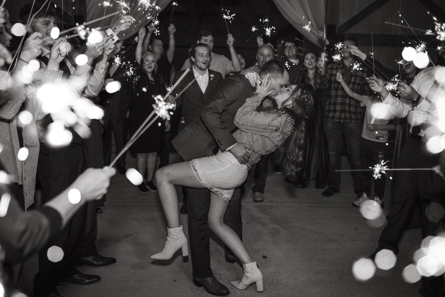 Wedding reception dance floor filled with guests under twinkling lights.