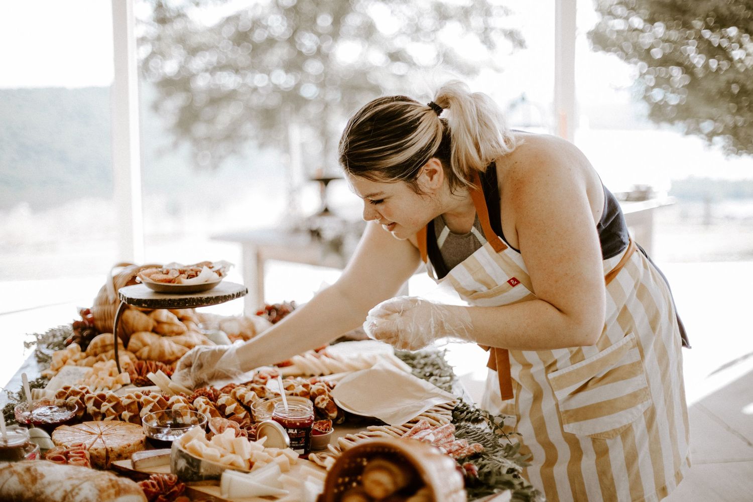Rustic wooden table with assorted meats and cheeses arranged on serving boards.