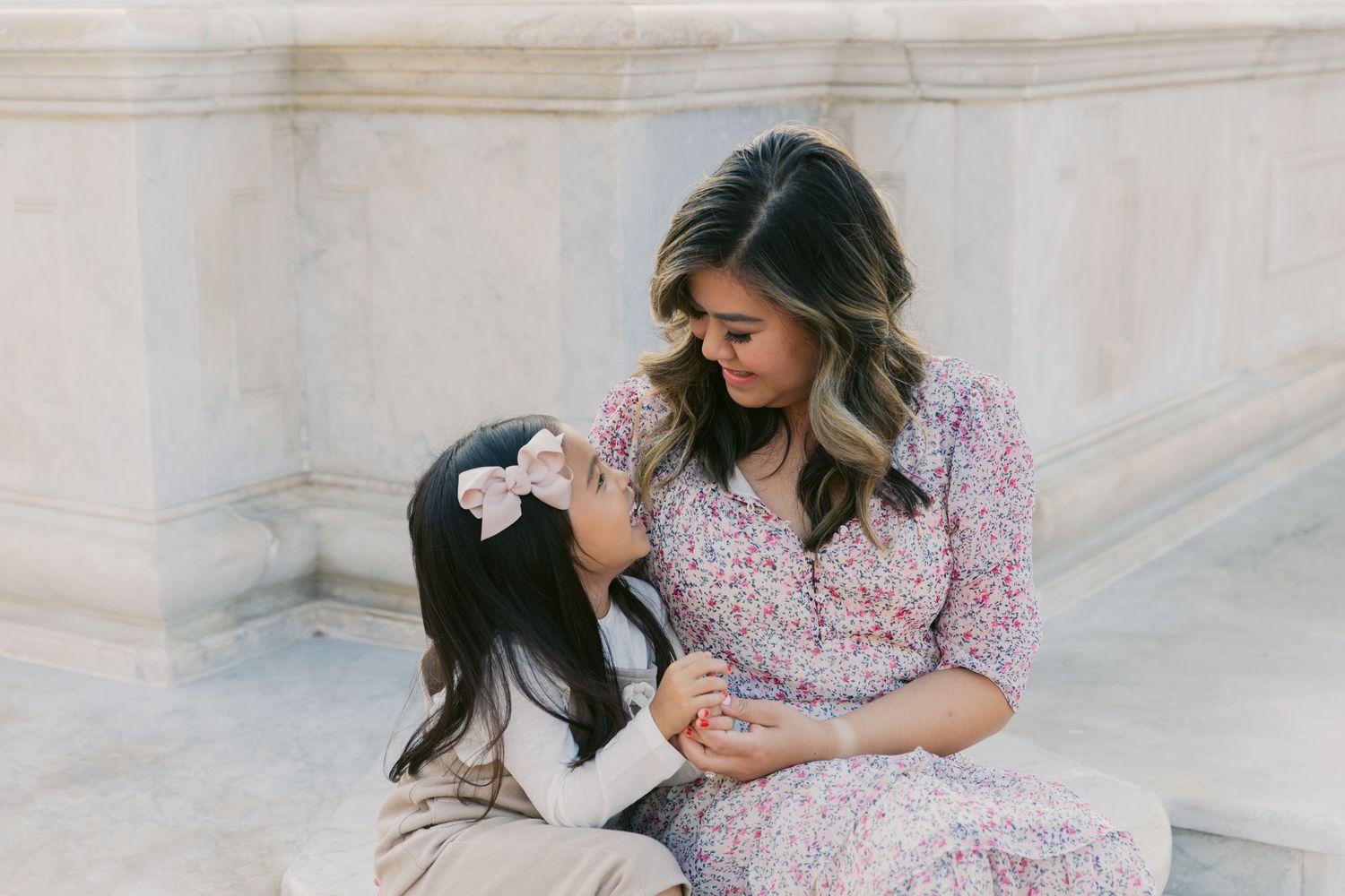 A family relaxes together on decorative marble steps during a casual photoshoot.