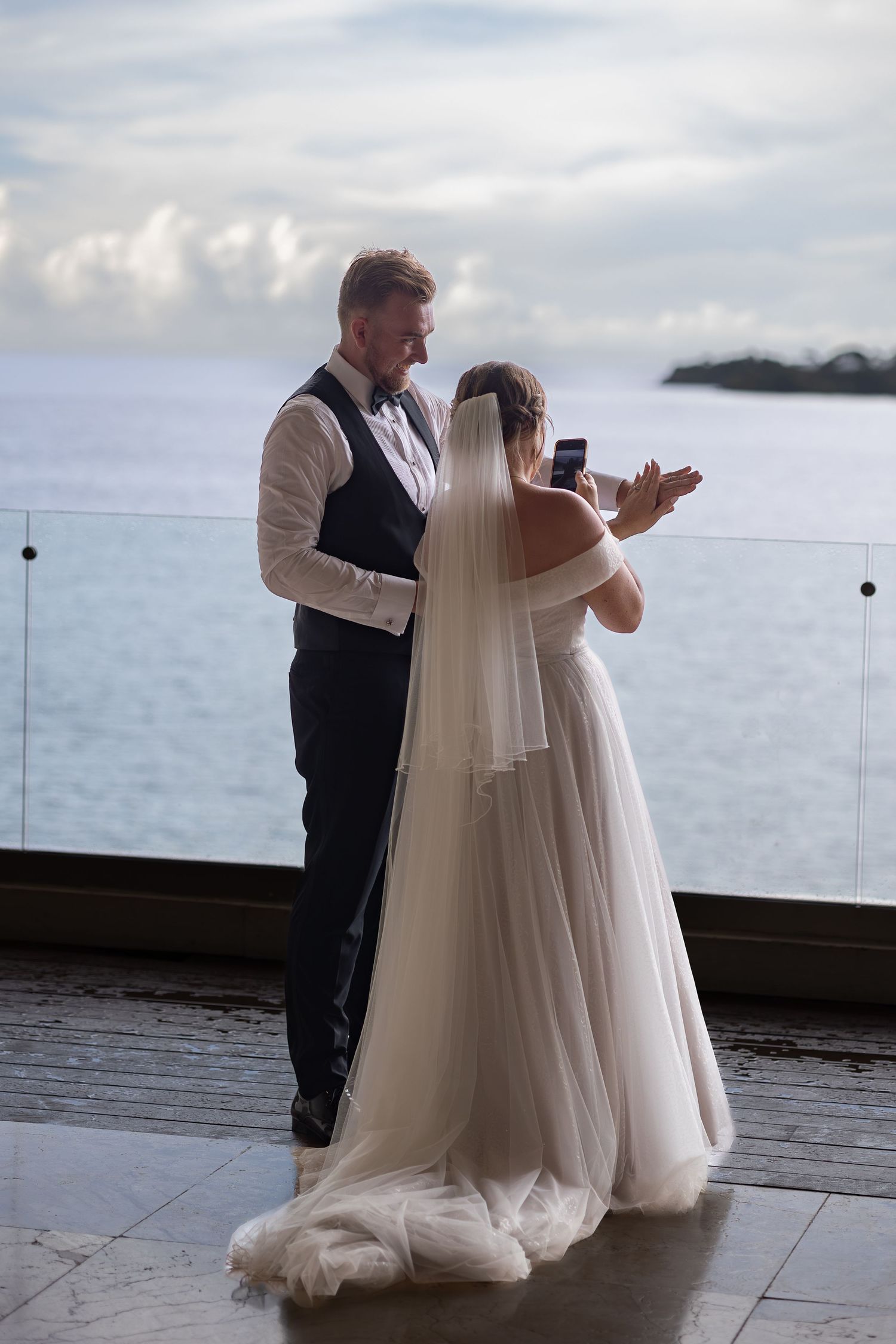 Bride and groom taking a photo of their wedding rings