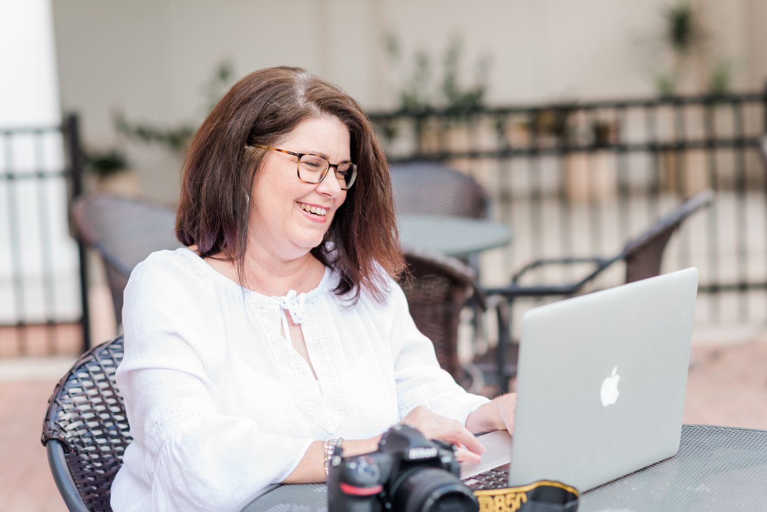 woman photographer sits at table working on her laptop downtown Winter Haven