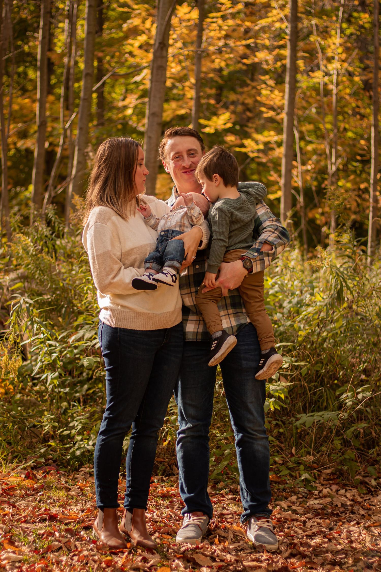 A family of 4 in the forest in the fall