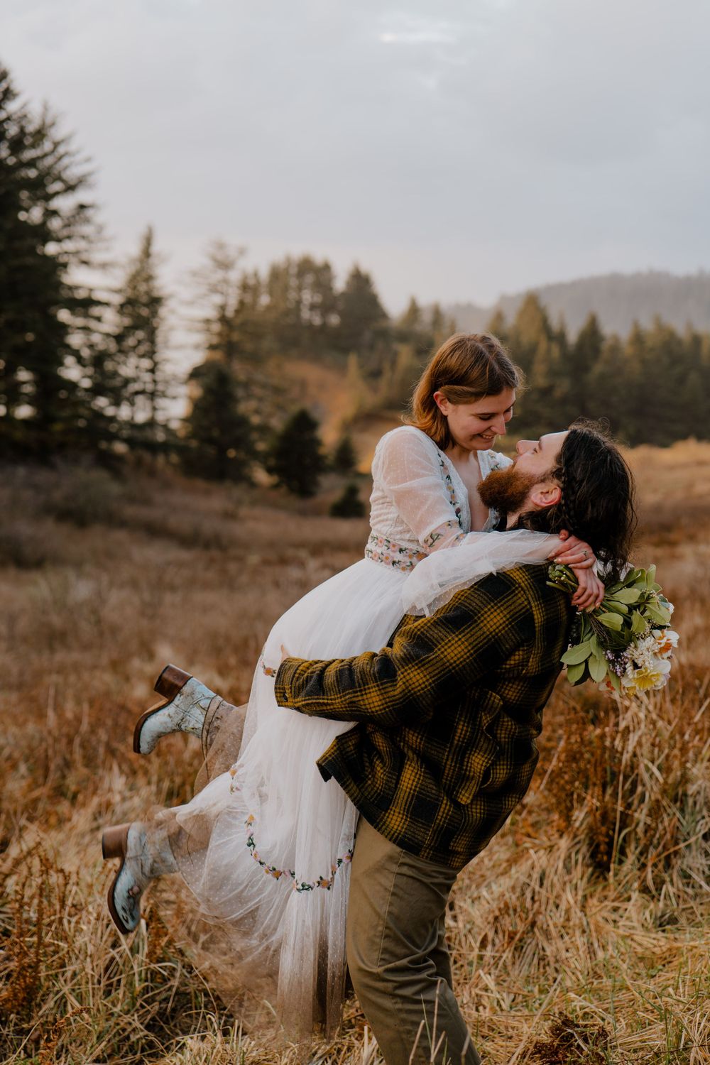 Bride kicking her feet back while groom lifts her in the air