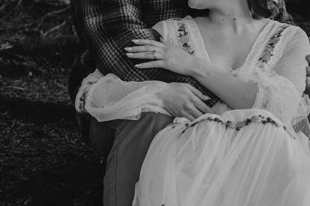 Black and white of bride holding grooms arm