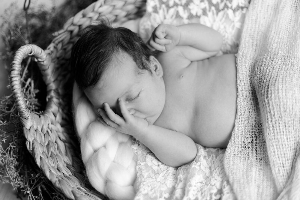 Black and white close-up photos of tender newborn baby moments with parents.