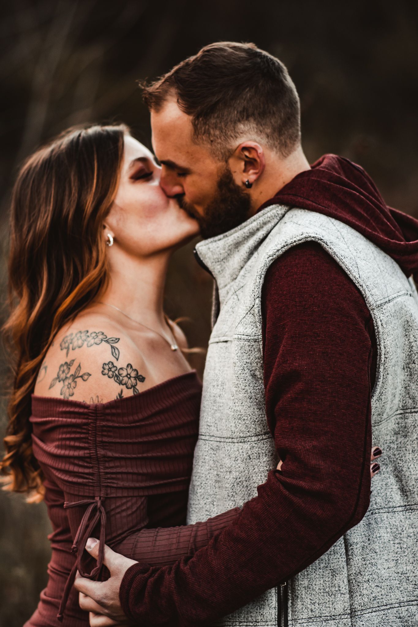 A tender moment between a couple wearing coordinated outfits during their autumn photo session.