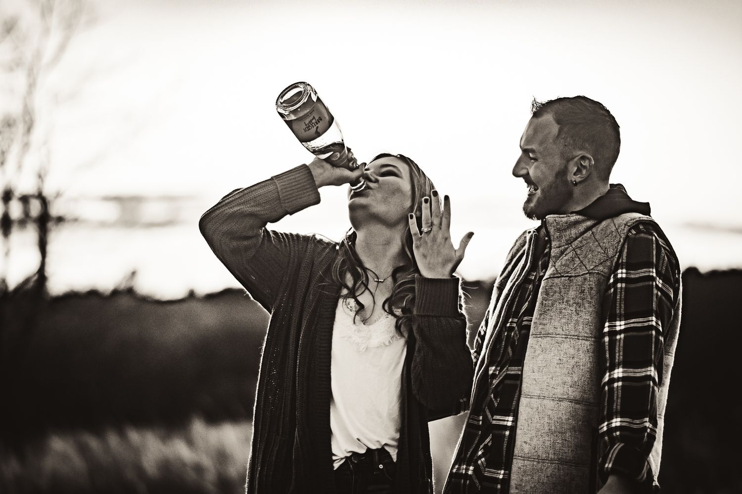 Black and white photo of a couple enjoying drinks outdoors together.