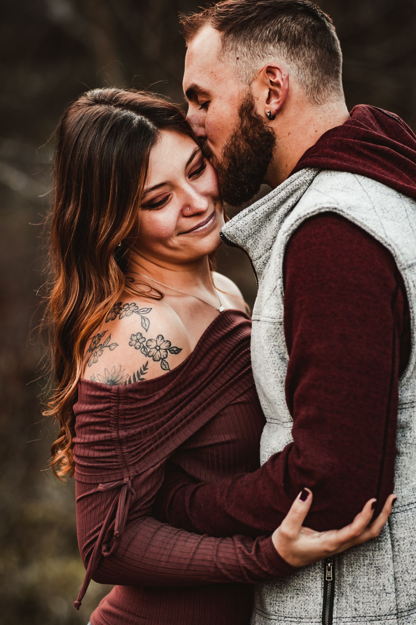 Intimate moment between couple wearing burgundy and gray sweaters.