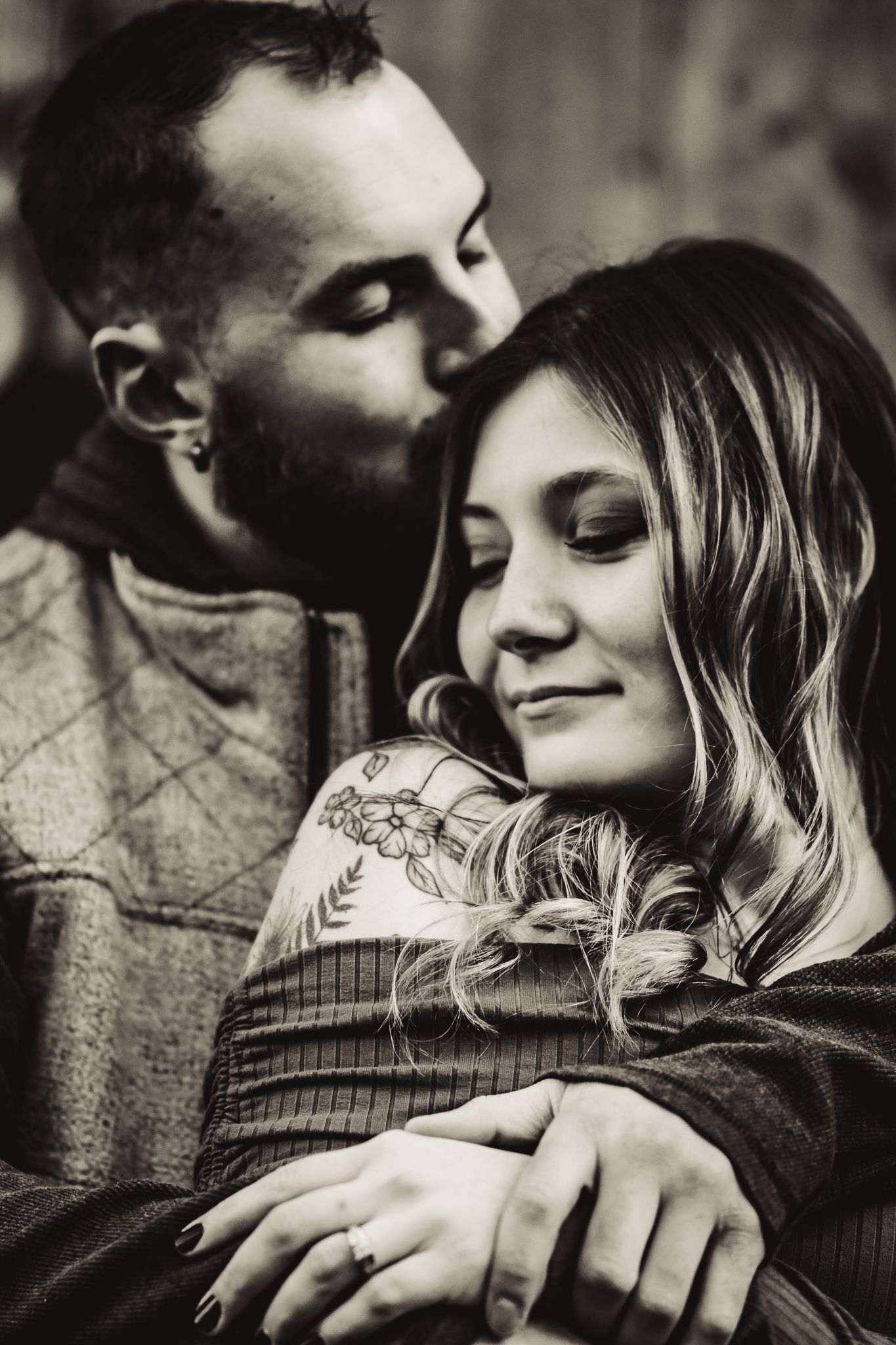 Black and white intimate photo of couple sharing tender moment in warm embrace.