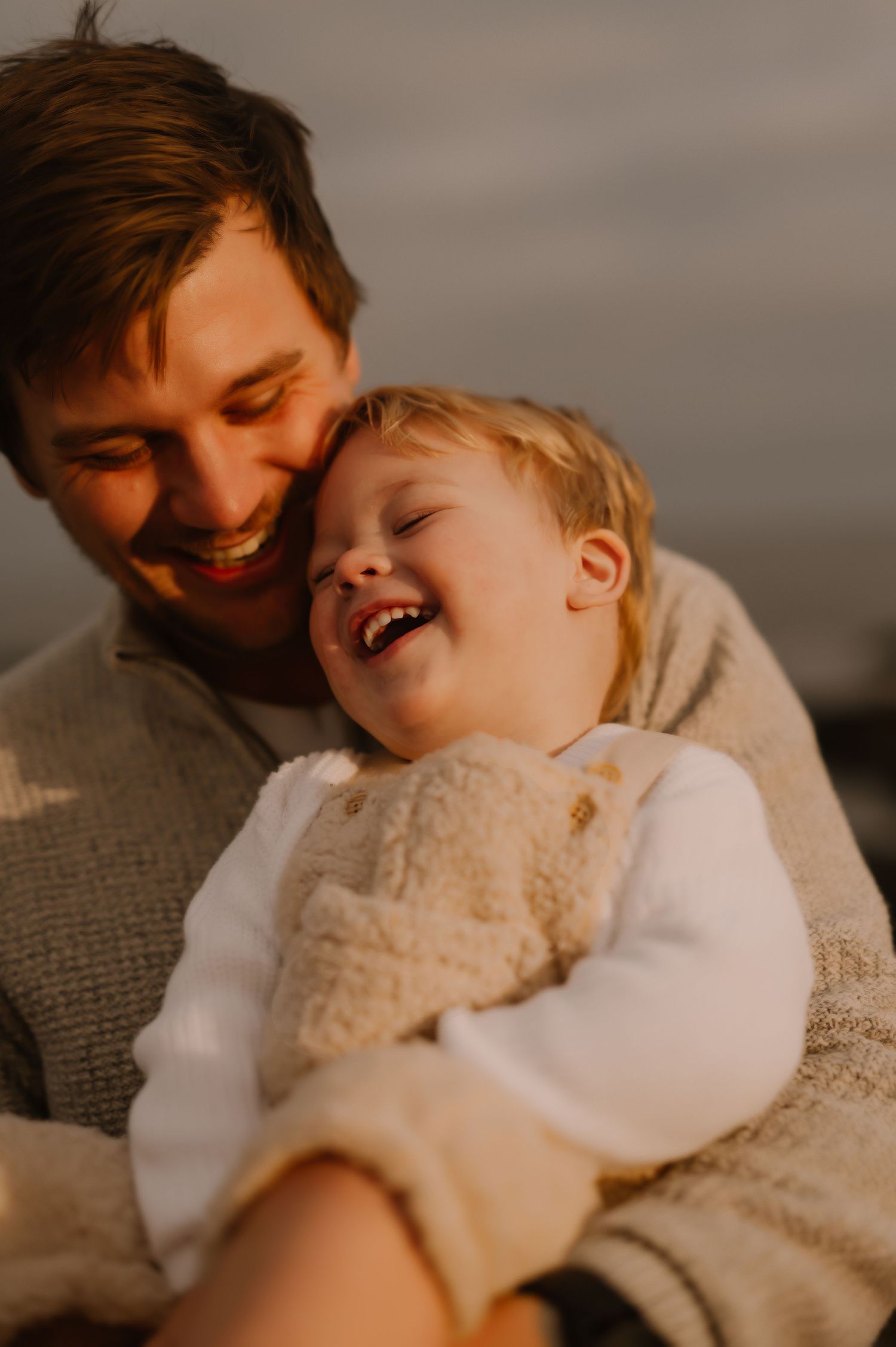 A tender moment of shared laughter captured in warm evening light.