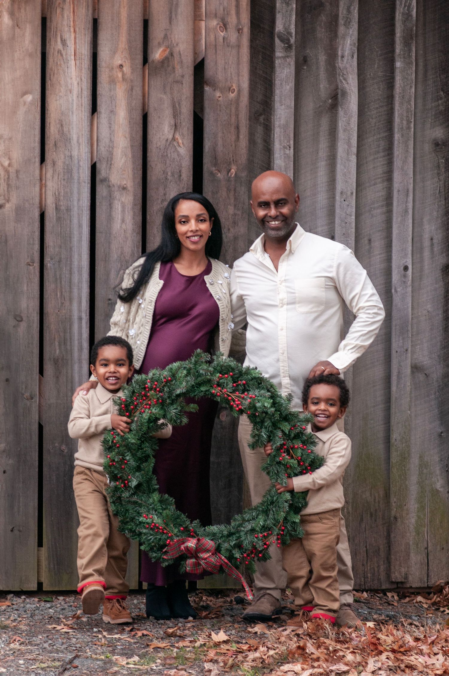 Family holiday photo near barn with wreath