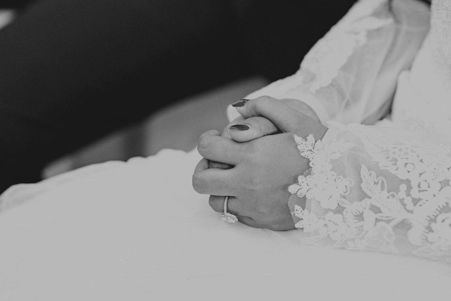 Black and white detail shot of delicate lace wedding dress fabric.