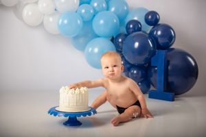 Baby boy birthday session photos; Lexington, SC photographer; Cake Smash session with shades of blue balloons on white