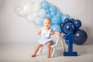 Smiling 1 year old boy photoshoot; shades of blue balloons birthday photo session; Lexington, SC portrait studio photos