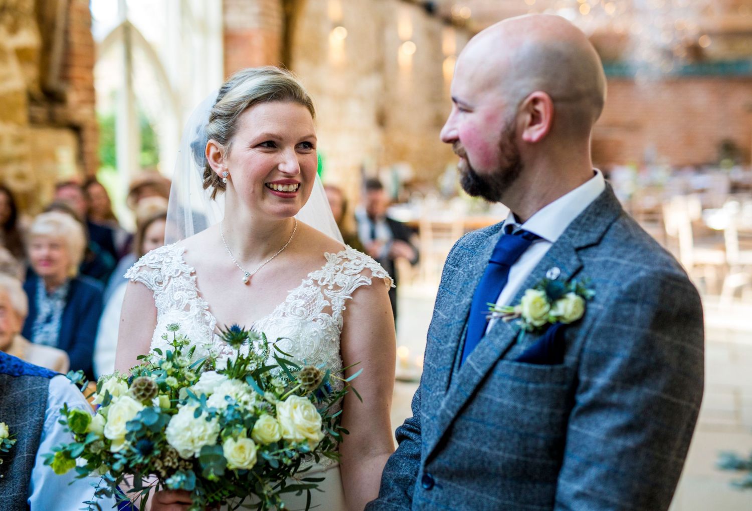 Wedding celebration in a rustic venue with stone walls and floral decorations.