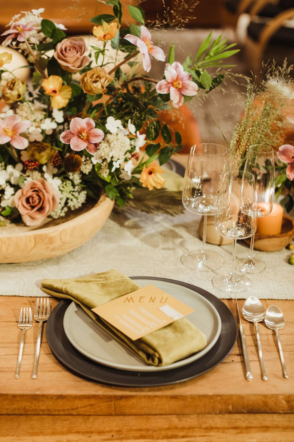 An elegant table setting with a floral centerpiece, wine glasses, and place settings for a special occasion.