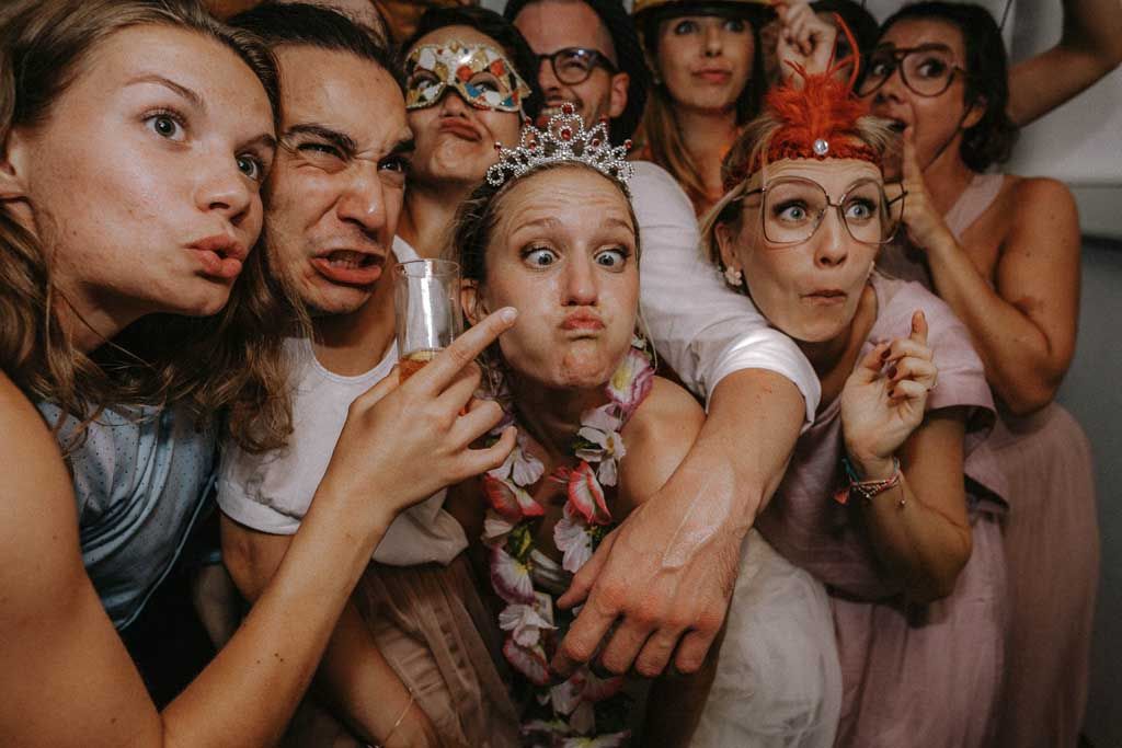 Group photo of wedding party making silly faces and poses together.