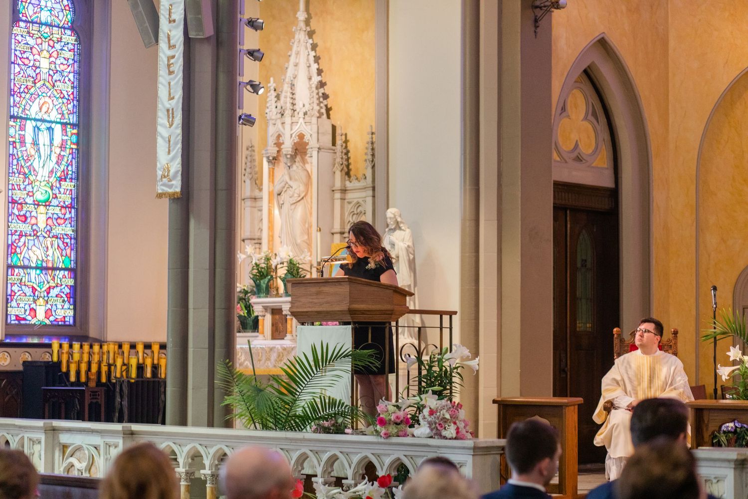 Church interior with stained glass windows and altar during wedding ceremony.
