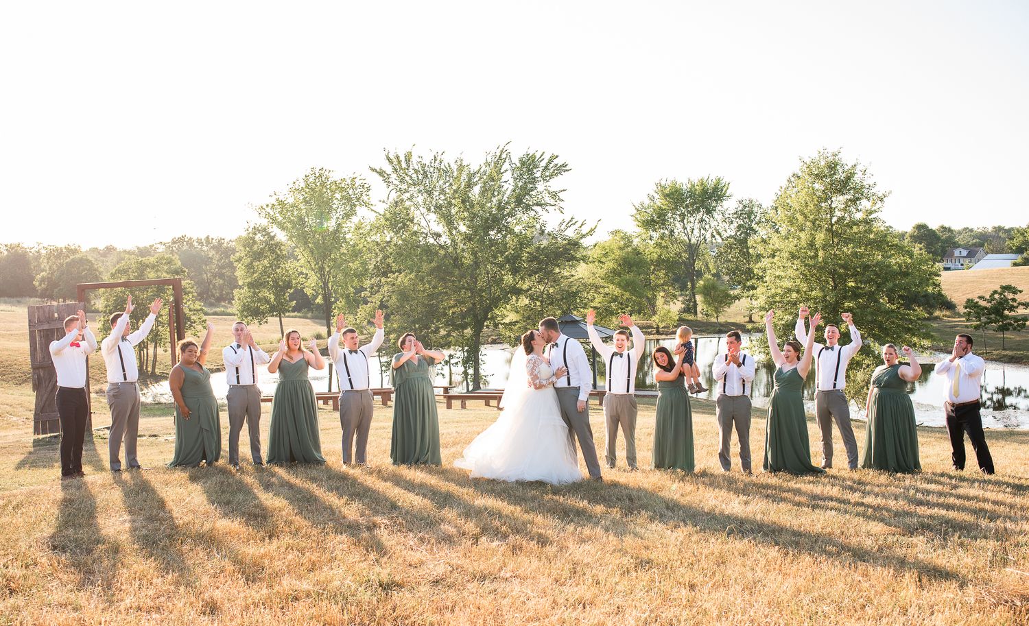 Wedding party celebrating as the couple kisses