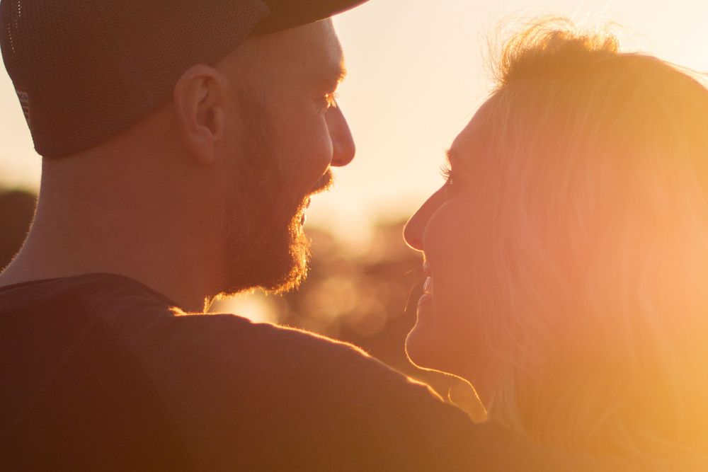A couple looks at each other lovingly during golden hour