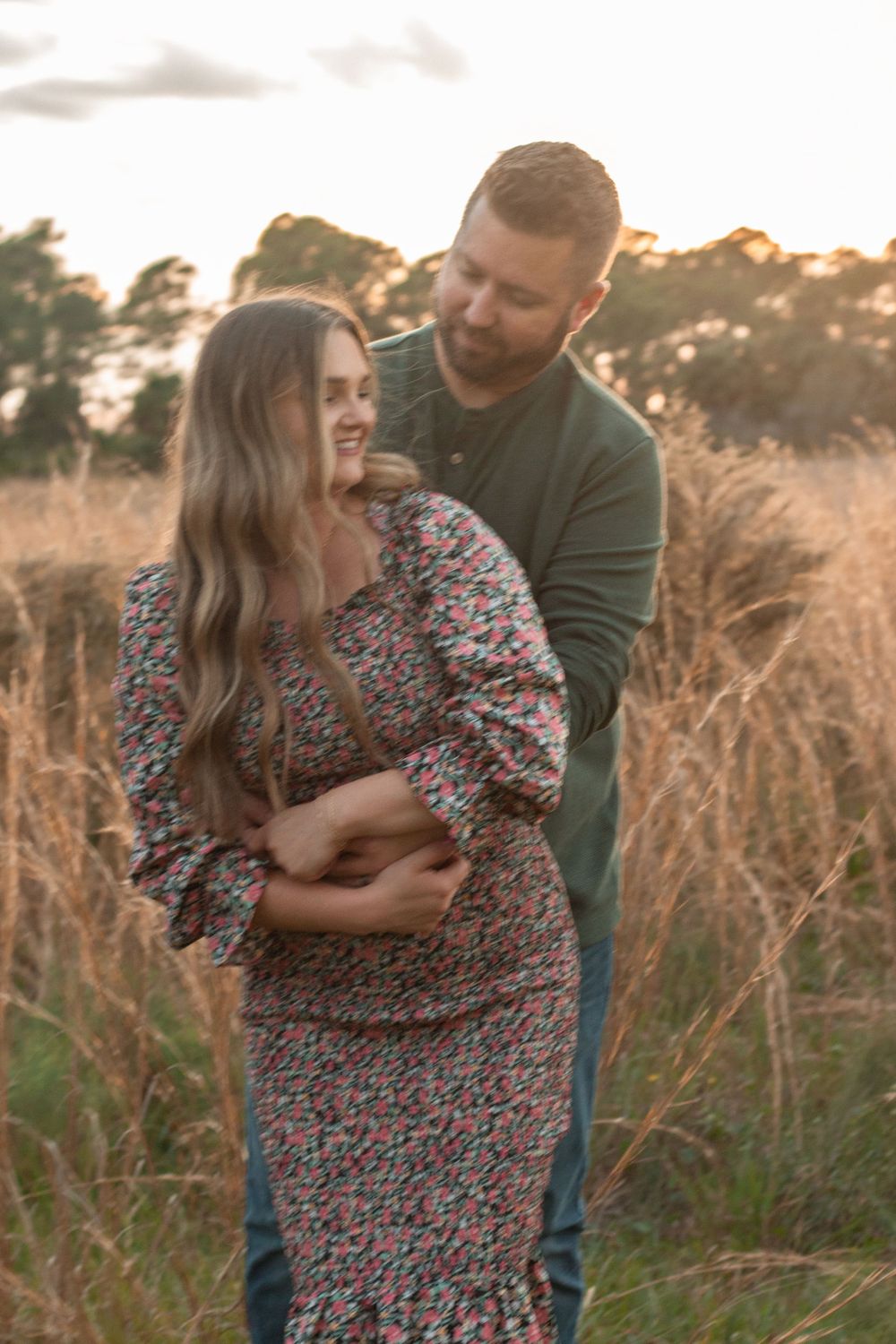 Couple smiling at each other in field in Stuart, Florida