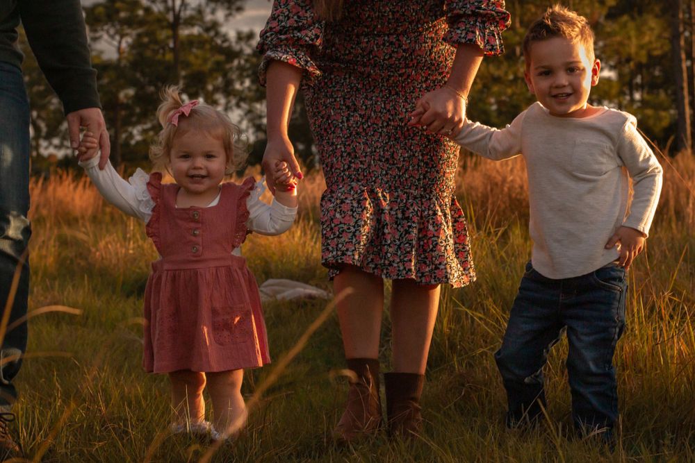 Family laughing together and children looking at camera in a field in Stuart, Florida